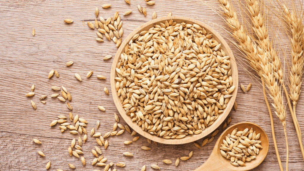 wheat seeds in a wooden spoon on a wooden table