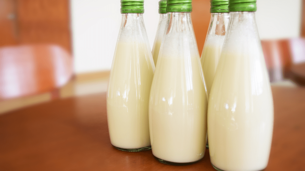 bottles of milk sitting on top of a wooden table