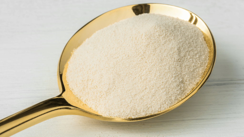 a spoon full of white powder sitting on top of a wooden table