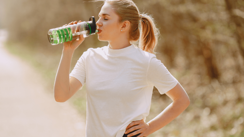 a person is drinking water from a water bottle