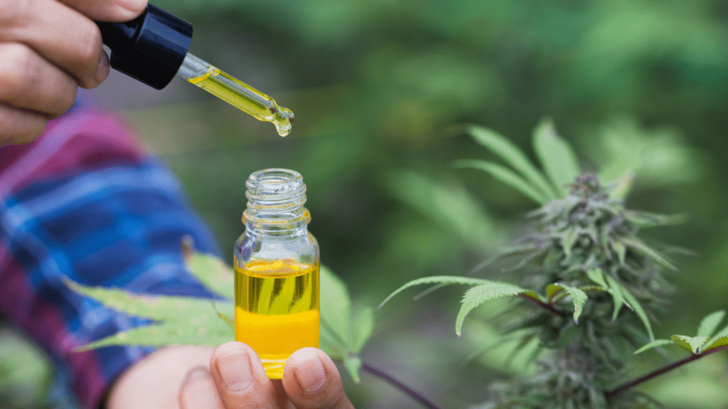 a person holding a bottle of cbd oil