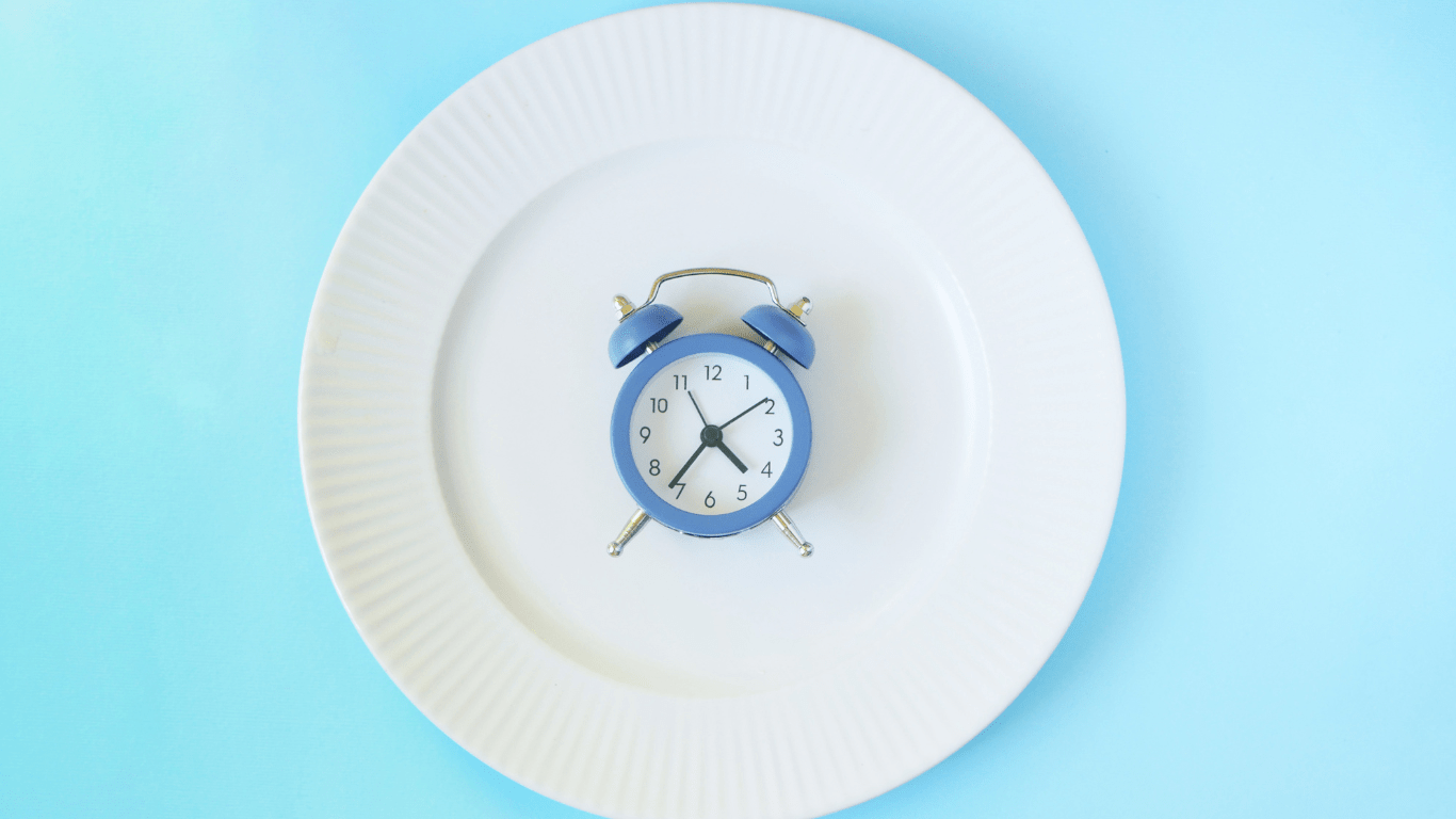 an alarm clock on a white plate on a blue background