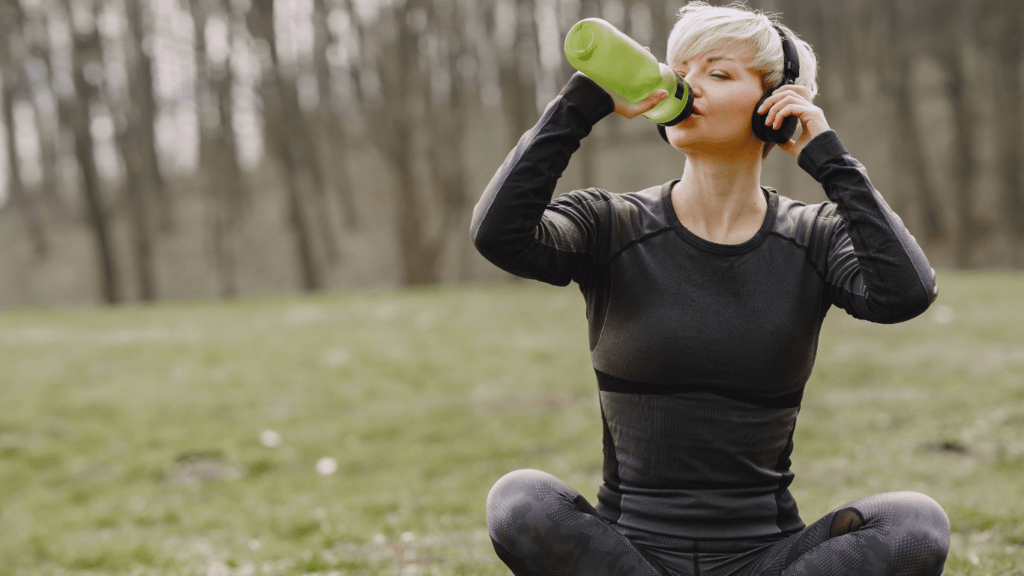 a person is drinking water from a water bottle