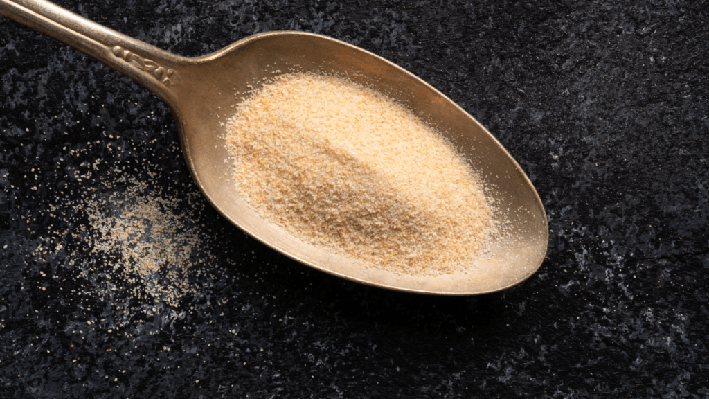 a spoon full of white powder sitting on top of a wooden table