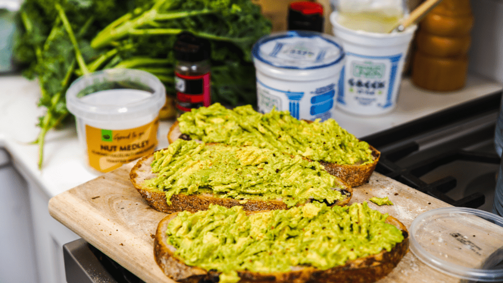 avocado toast with eggs and avocado on a white plate