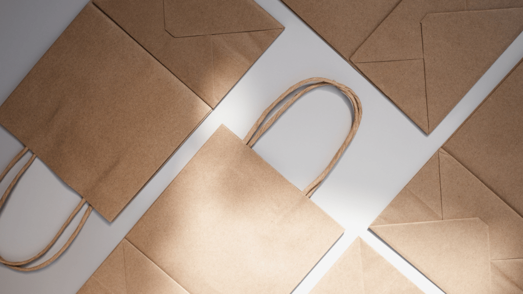 three brown paper bags with handles on a white background