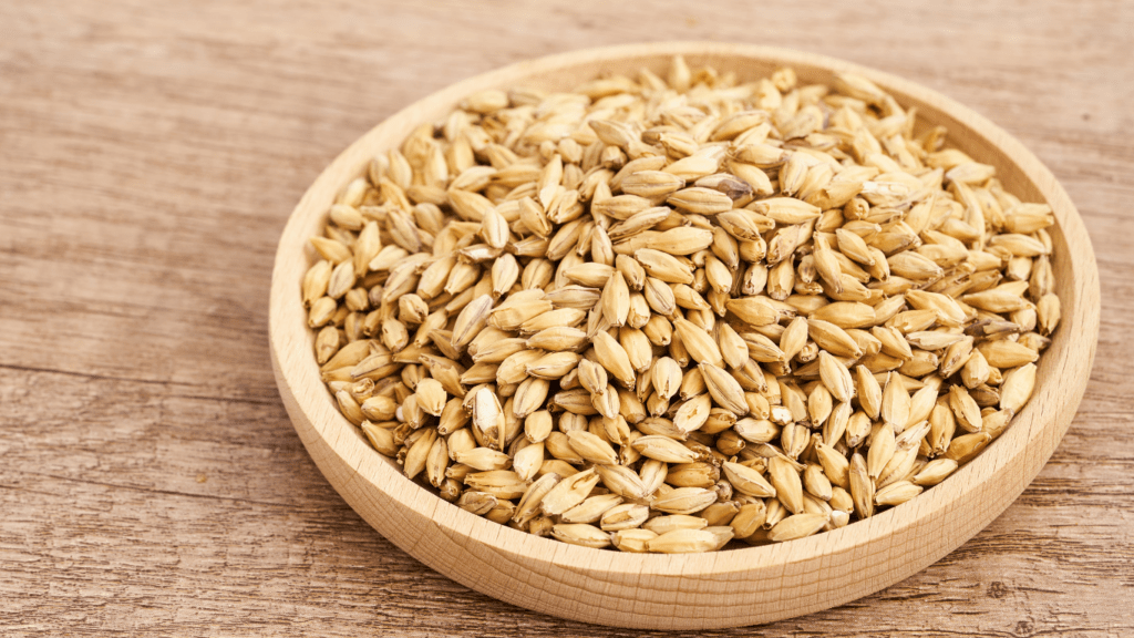 wheat seeds in a wooden spoon on a wooden table